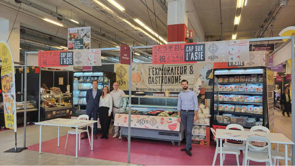 Une photo présentant l'équipe commerciale Agis sur son stand lors du salon Leclerc. Nous y voyons des banques avec des produits frais AGIS (plats cuisinés et spécialités exotiques)