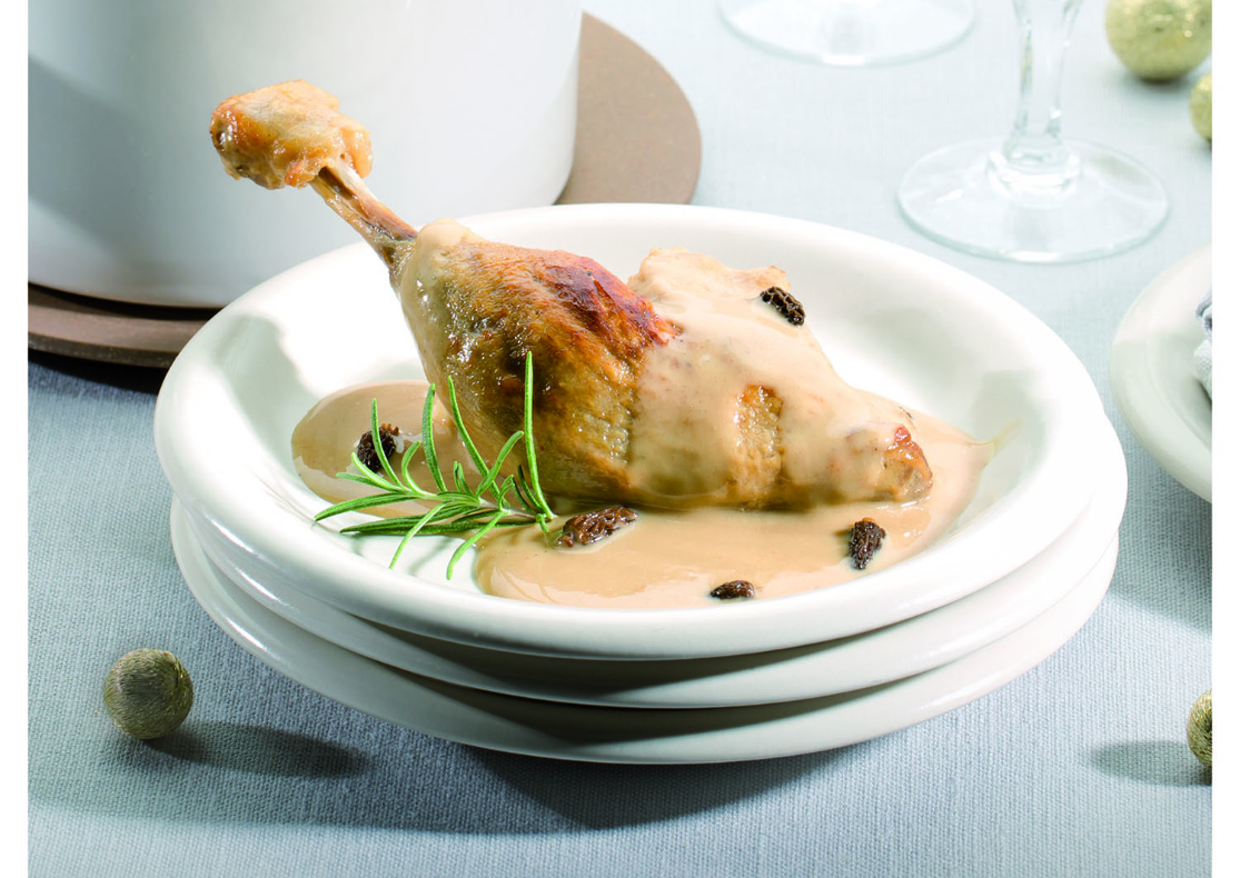 Une cuisse de canard présentée dans une assiette avec une sauce crémeuse agrémentée de morilles